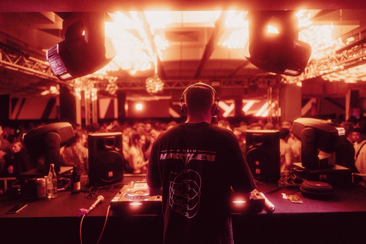DJ performing under red stage light