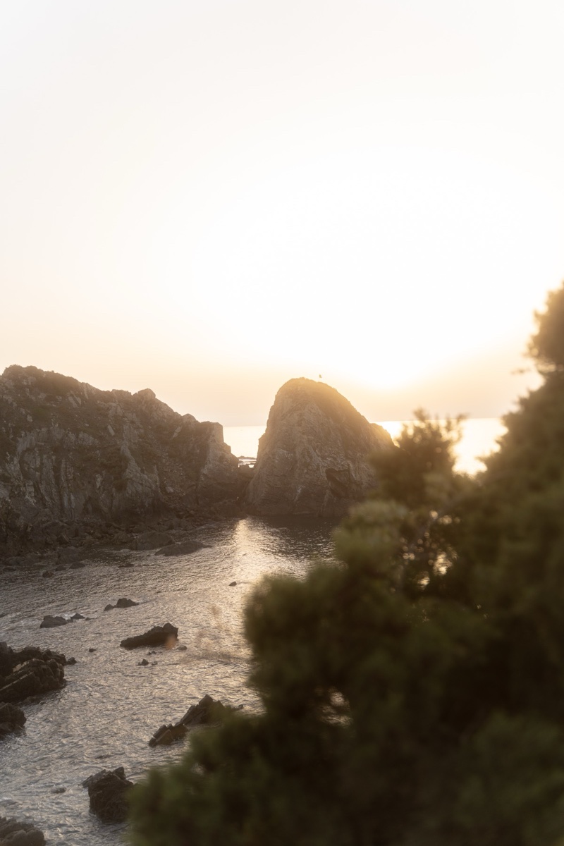 Coastal sunset with rocks and sea