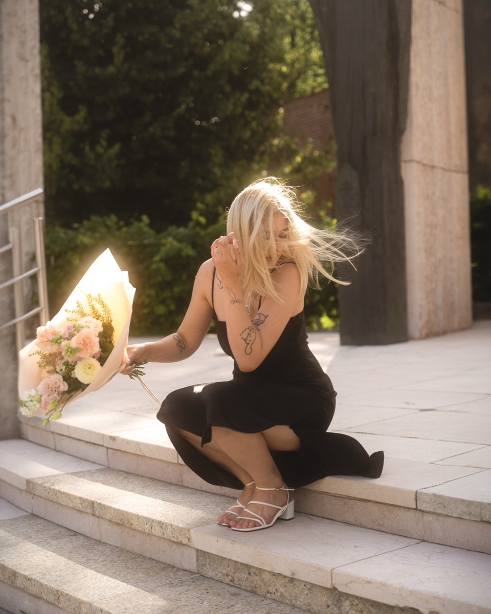 Portrait in a black dress holding a bouquet