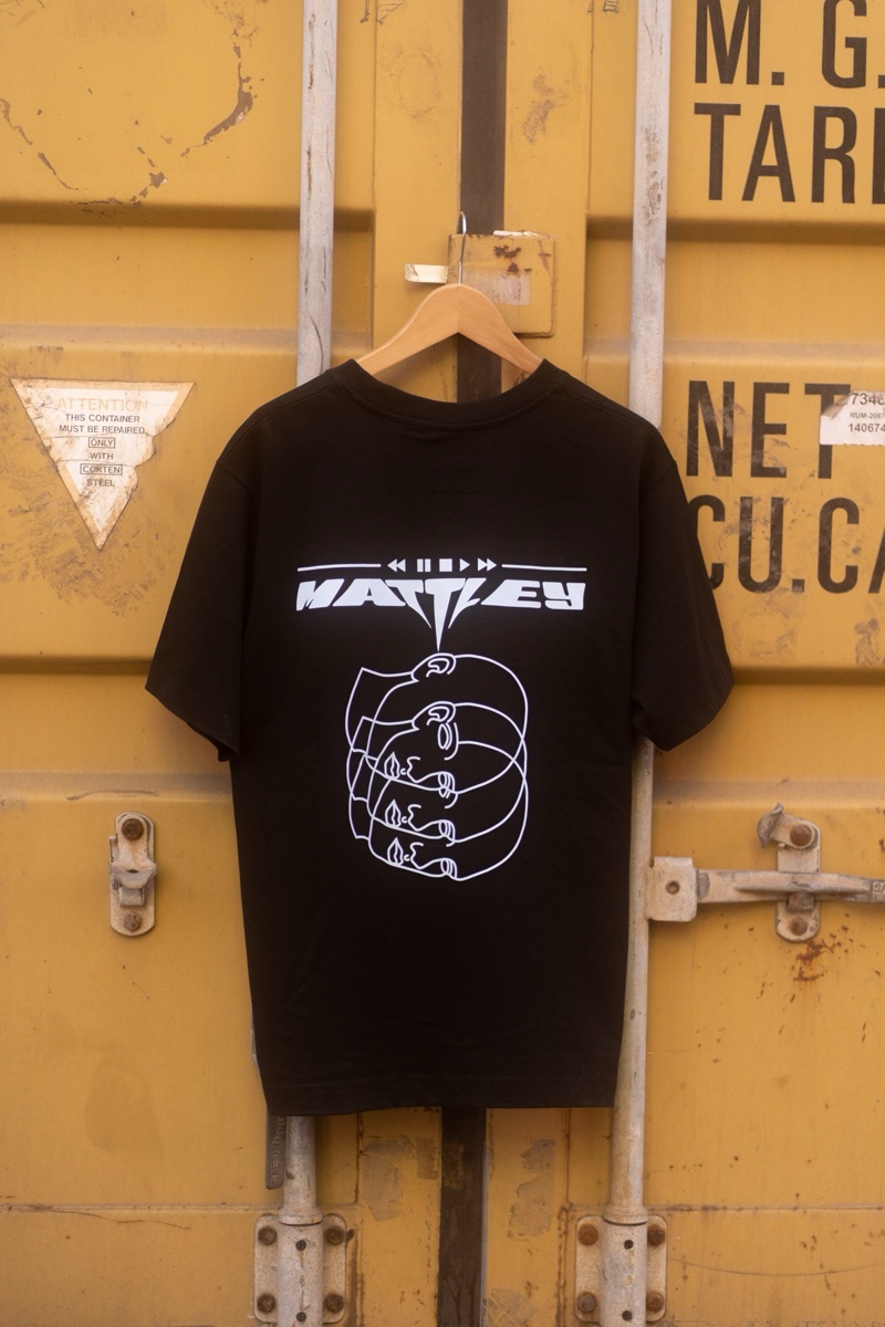 MATTLEY tee on a hanger against a yellow container