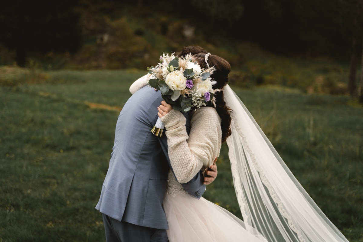 Couple embracing, bride in veil