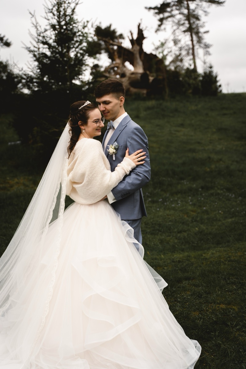 Bride and groom embrace outdoors