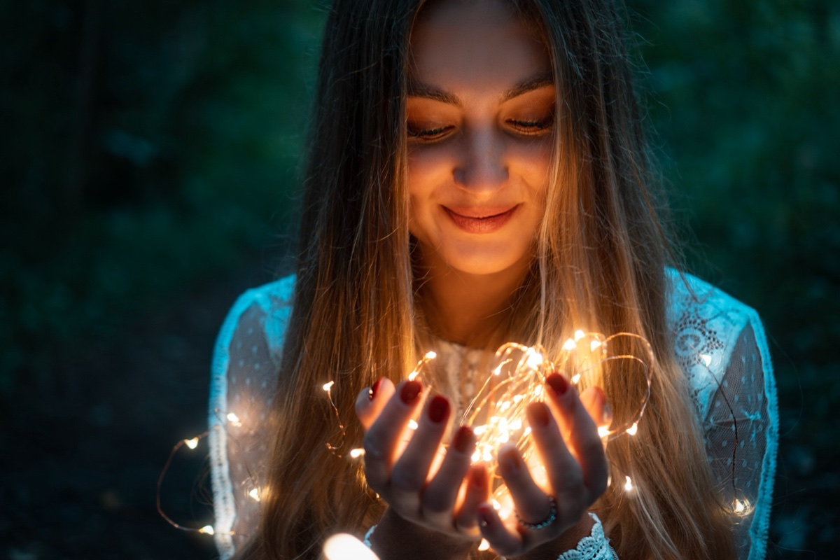 Portrait holding fairy lights at night